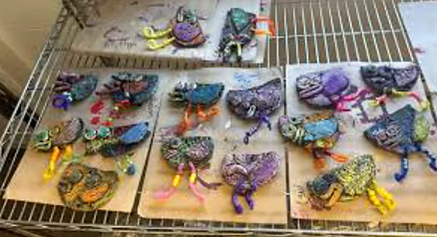 Colorful hand-painted clay sea creatures made by Art & Craft Club students, drying on a rack.